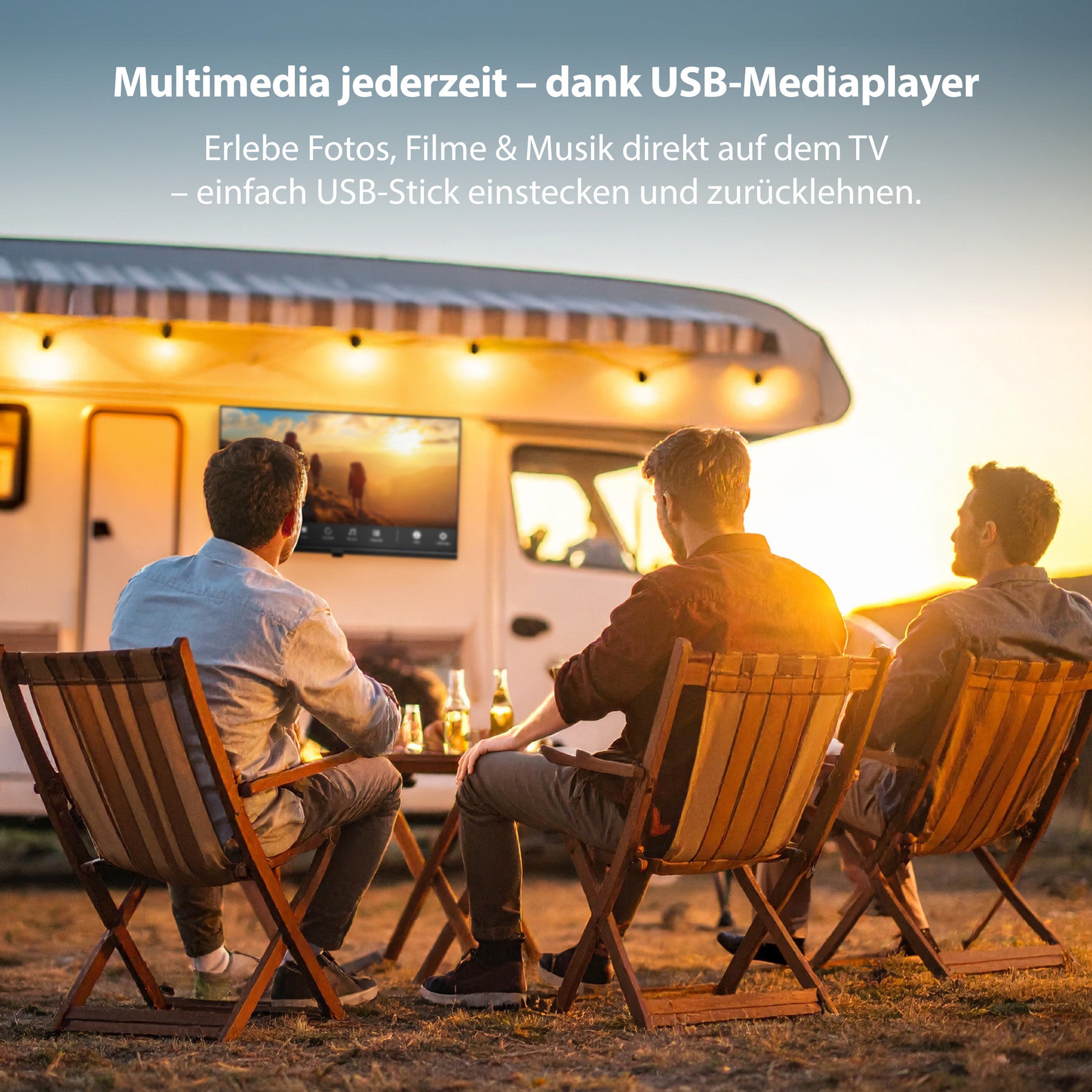 Drei Personen sitzen bei Sonnenuntergang auf Klappstühlen im Freien und sehen sich einen Film auf dem Dyon Enter 24 Pro-X-V Standard-TV (24 Zoll, 60 cm) an, der an einem Wohnmobil befestigt ist. Der Text hebt die USB-Media-Player-Funktionen des Fernsehers für mobile Unterhaltung hervor.