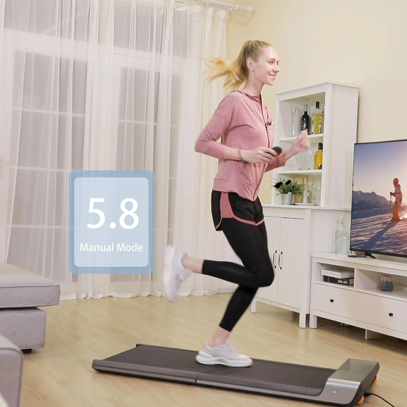 Eine Frau joggt auf einem Kingsmith WalkingPad P1 Klappbares Laufband für Schreibtisch in ihrem Wohnzimmer. TV und Sofa sind zu sehen, und das Display zeigt 5.8 Manual Mode-ideal als platzsparendes Laufband für das Training zu Hause.