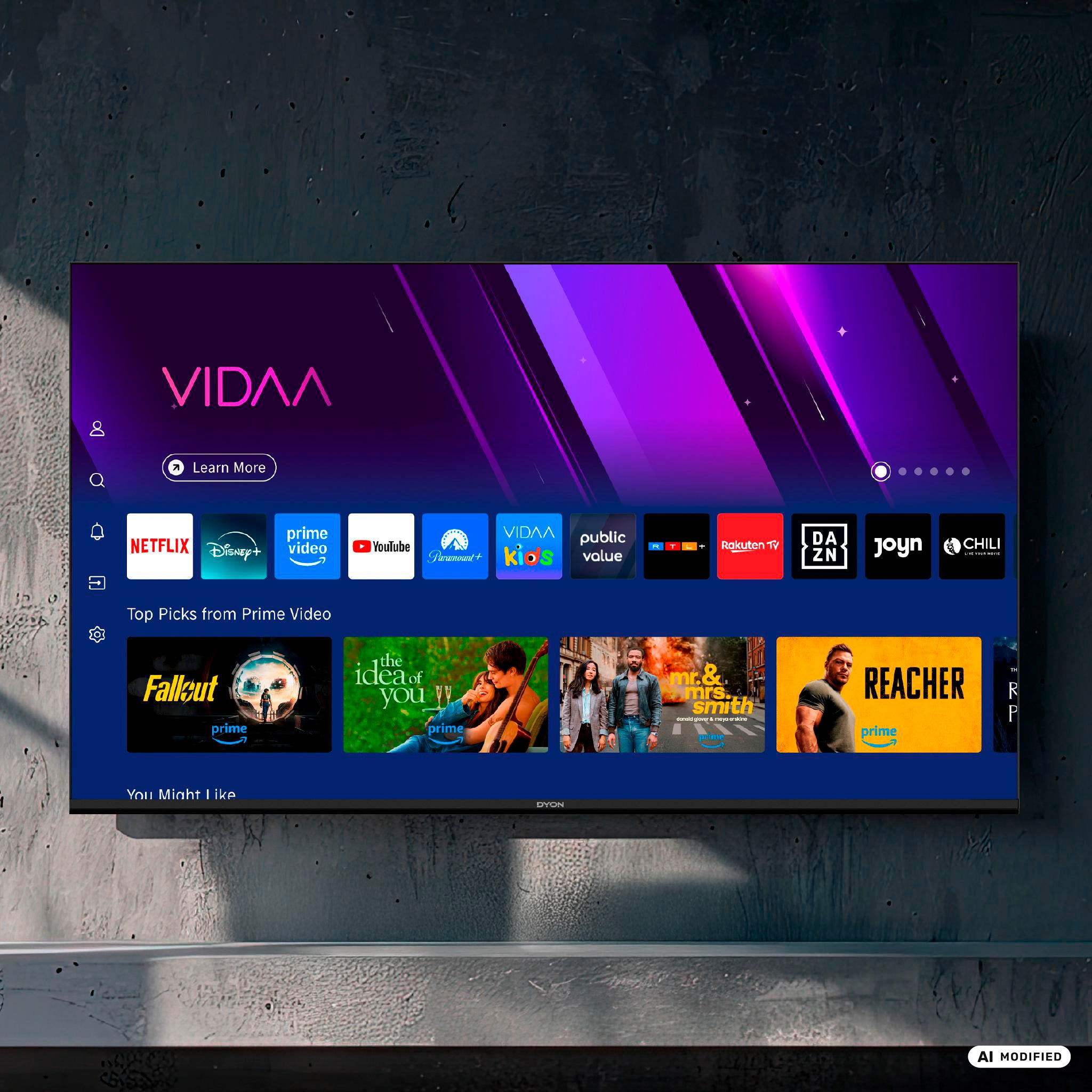 An der Wand ist ein Dyon Movie Smart 32 VX 32-Zoll-HD-Smart-TV angebracht, auf dem die VIDAA-OS-Benutzeroberfläche mit App-Symbolen wie Netflix, Prime Video und YouTube sowie beliebten Serien wie „Fallout“, „The Idea of You“, „Mr. & Mrs. Smith“ und „Reacher“ zu sehen ist.