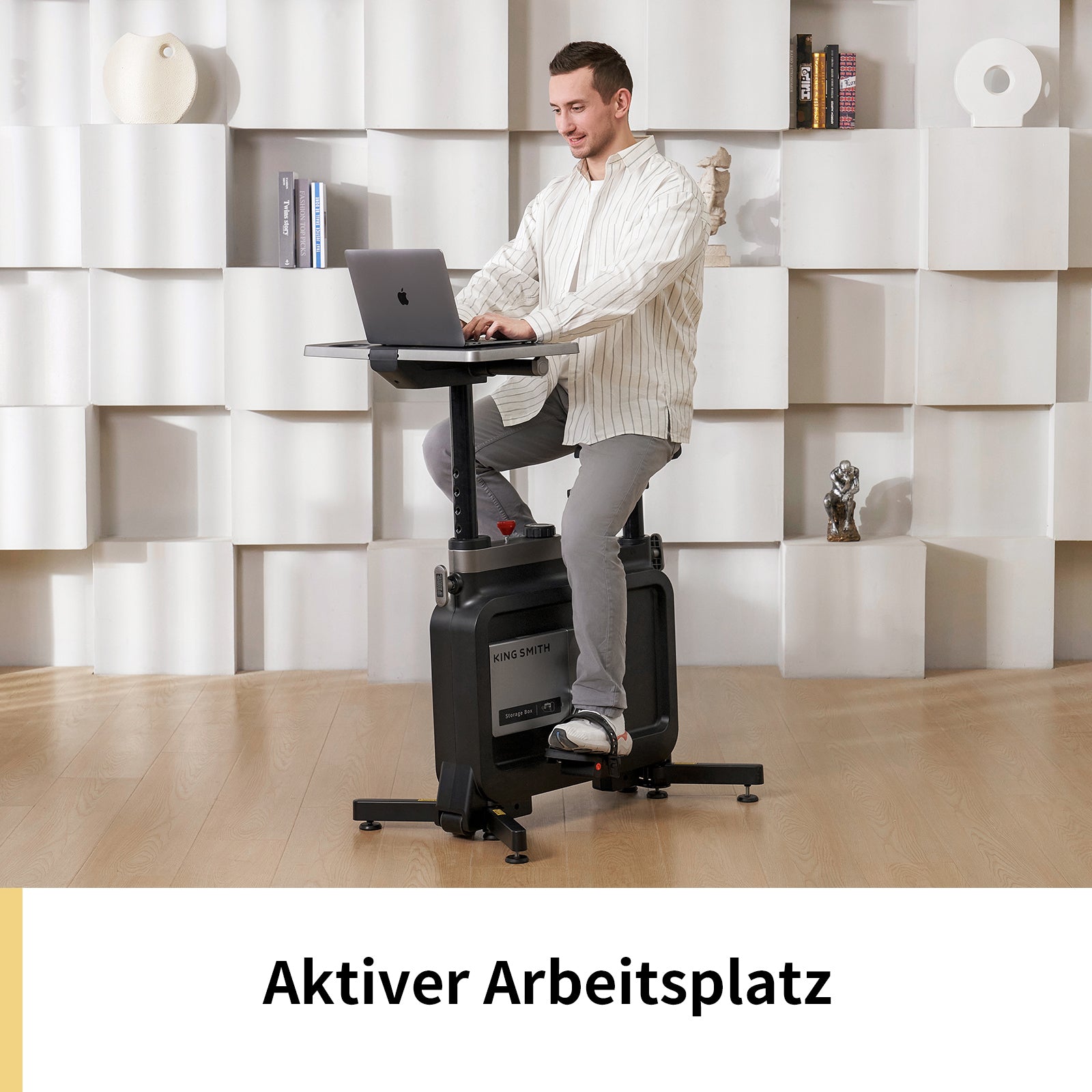 Ein Mann arbeitet an einem Laptop an einem höhenverstellbaren Schreibtisch, während er auf dem Kingsmith Office Bike W1B von Kingsmith sitzt und so sein Bürotraining mit Produktivität in einem modernen, weiß dekorierten Raum verbindet.
