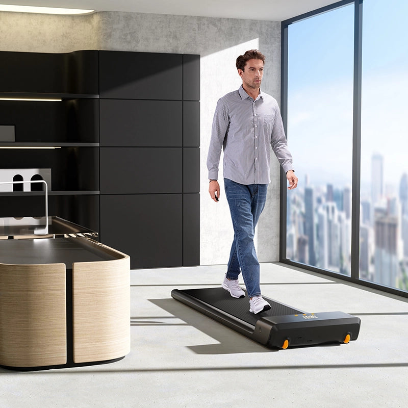 Ein Mann läuft auf einem Kingsmith WalkingPad A1 Pro Klappbares Laufband in einem modernen Bürohochhaus mit großen Fenstern und Blick auf die Stadt.