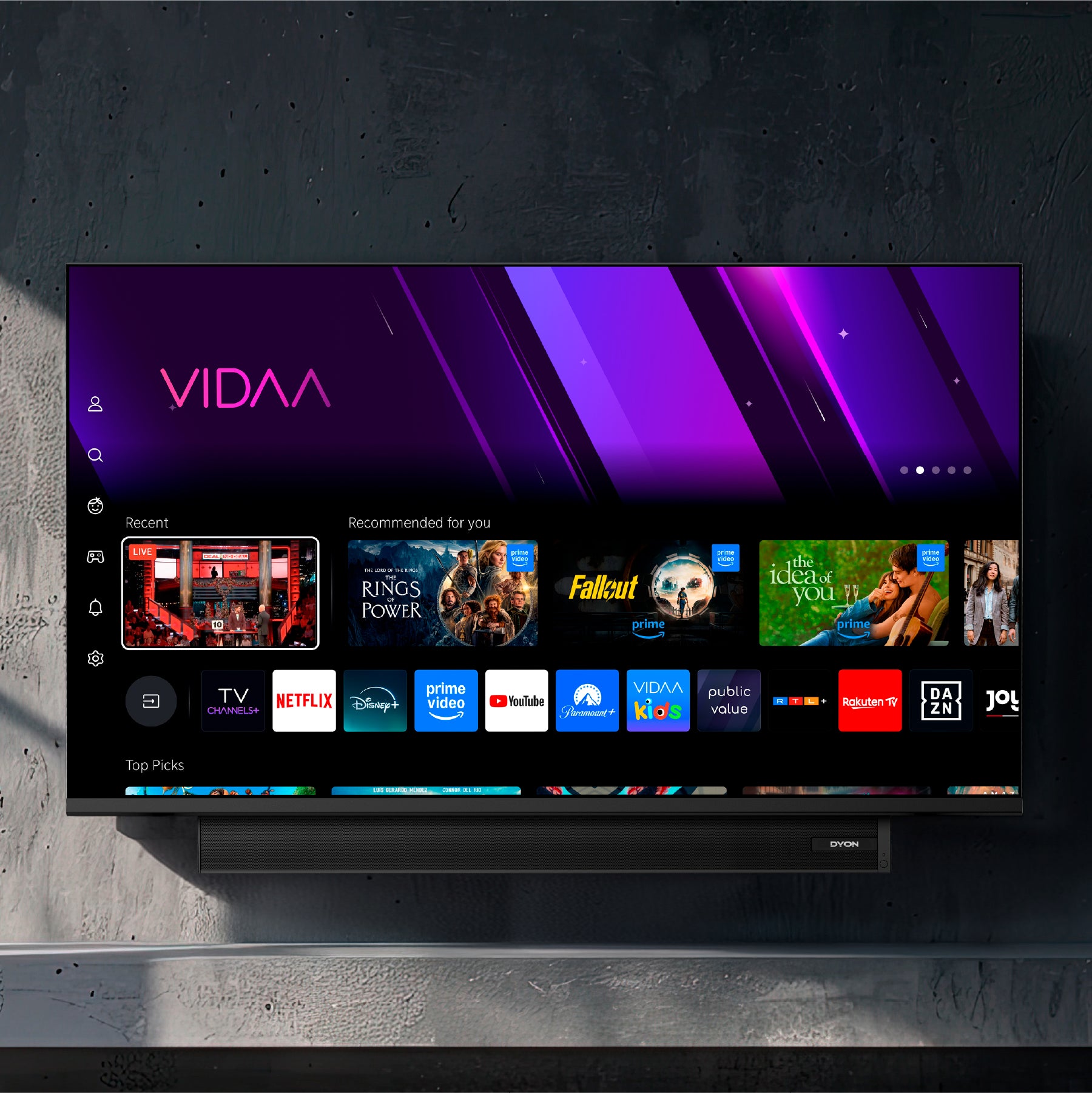 Ein Dyon Movie Smart 32 VX-S (32 Zoll, 80 cm) Flachbildfernseher ist an einer dunklen Wand montiert und zeigt die VIDAA Smart-TV-Oberfläche mit Streaming-Apps und Empfehlungen auf dem Bildschirm.