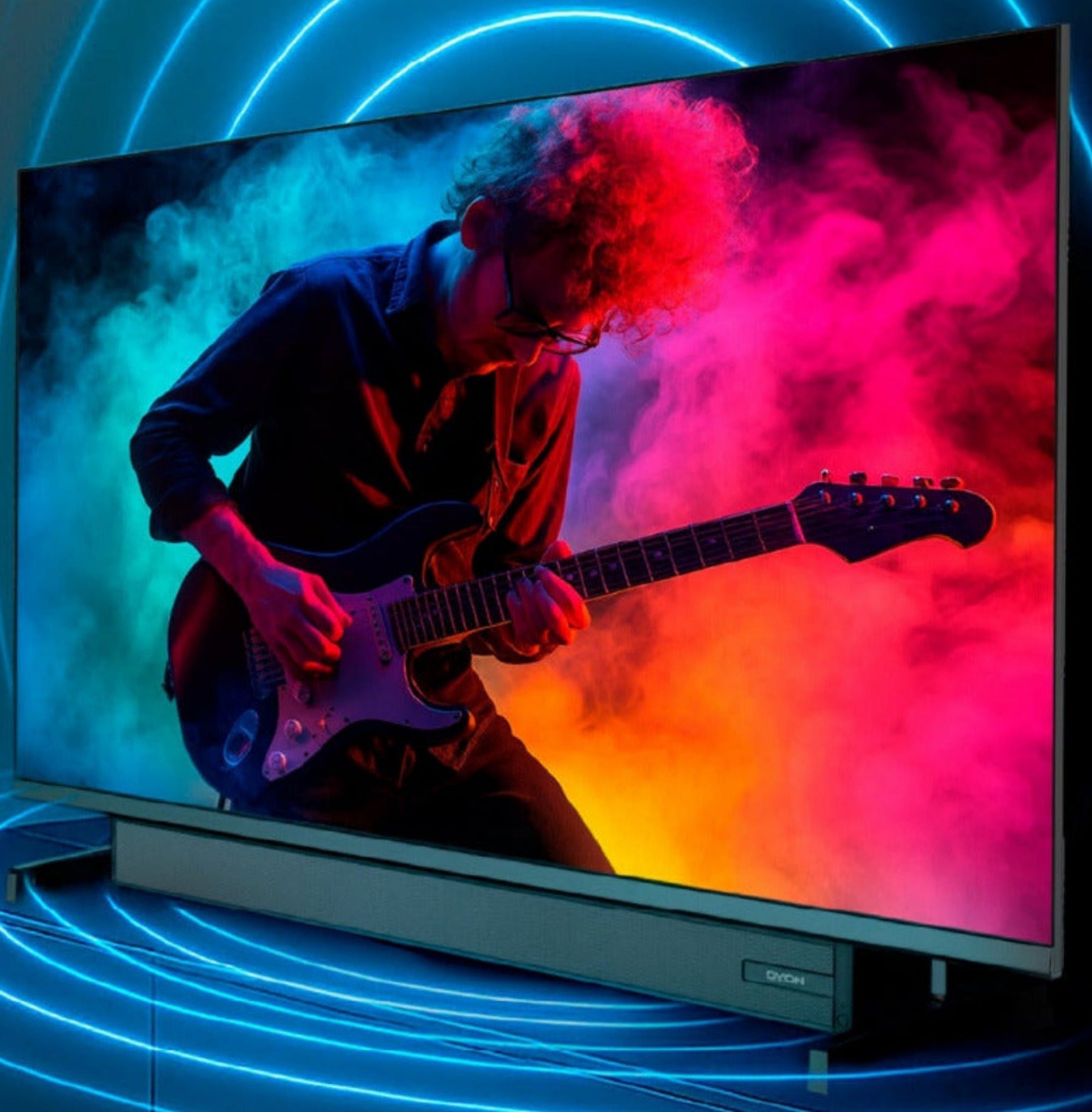 Der Fernseher DYON Movie Smart 32 VX-S (32 Zoll, 80 cm) zeigt ein lebendiges, gitarristisches Bild mit digitalen, blauen Ringen, die die vom Bildschirm und der Soundbar ausgehenden, beeindruckenden Klangwellen darstellen.