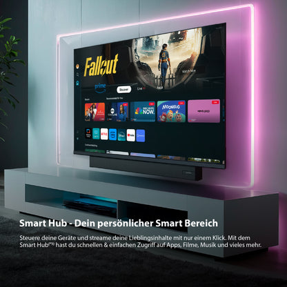 In einem modernen Wohnzimmer steht der Smart-TV Dyon Ultimax 32H-TI-WS (32 Zoll, 80 cm) mit Media-Hub-Schnittstelle, umrahmt von Neonröhren und ergänzt durch eine Soundbar darunter.