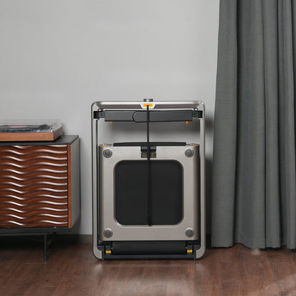 Das Kingsmith WalkingPad X214 Klappbares Laufband steht aufrecht an einer Wand neben einem modernen Holzschrank und einem grauen Vorhang auf einem Holzboden und unterstreicht das schlanke und platzsparende Design des Fitnessgeräts.